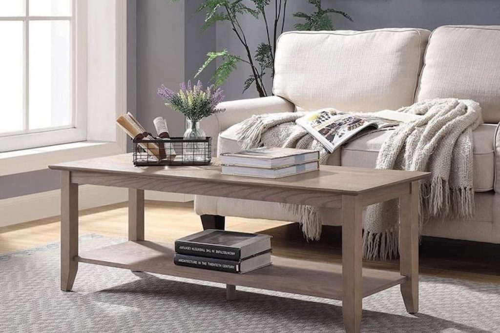 Hamptons living room decor with a large whitewashed MDF coffee table, light blue accent pillows, and coastal table lamps.