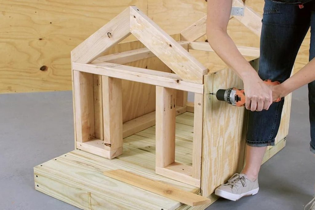 Durable outdoor timber dog house with a pitched asphalt roof, elevated legs, and offset doorway in a grassy backyard, designed for Husky comfort and weather protection.